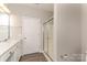 Bright bathroom featuring a white sink vanity, a glass enclosed shower, and wood-look floors at 14967 Santa Lucia Dr, Charlotte, NC 28277