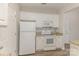 Bright kitchen boasts white appliances, white cabinetry, and stylish backsplash at 14967 Santa Lucia Dr, Charlotte, NC 28277