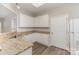 Well-lit kitchen features granite counters, white cabinets, and wood-look flooring at 14967 Santa Lucia Dr, Charlotte, NC 28277