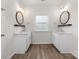 Double vanity bathroom with white cabinets and a large mirror at 17909 Wilbanks Dr, Charlotte, NC 28278
