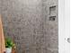 Walk-in shower with gray tile and built-in shelving at 19411 Greentree Way, Cornelius, NC 28031