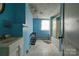 Bathroom featuring a white vanity, shower, blue walls and damaged ceiling at 2021 Willis Dr, Shelby, NC 28152