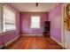 Bedroom with pink walls, wood floors, and visible damage at 2021 Willis Dr, Shelby, NC 28152