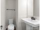 Bathroom features a pedestal sink, black hardware, and a sleek toilet in a neutral color palette at 3036 Arbor Ash St # 1022B, Charlotte, NC 28208