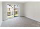 A bright, carpeted room with sliding glass doors leading to a backyard at 3036 Arbor Ash St # 1022B, Charlotte, NC 28208