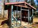 Exterior structure with wooden beam framework, open spaces, and potential for garden or storage at 308 N Hawthorne St, Mount Holly, NC 28120