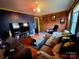 Cozy living room featuring brick wall accent, television, and comfortable seating at 308 N Hawthorne St, Mount Holly, NC 28120