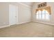 Bedroom with vaulted ceiling, neutral carpet, and a window with plantation shutters at 3850 Hounslow Ln, Harrisburg, NC 28075