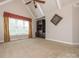 Spacious bedroom with vaulted ceilings, carpet, large windows, and a built-in shelving unit at 3850 Hounslow Ln, Harrisburg, NC 28075
