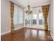 Dining room featuring hardwood floors, chandelier, large windows, and sliding glass door to outdoor patio at 3850 Hounslow Ln, Harrisburg, NC 28075