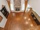 Open floor plan with stone fireplace, built-ins, hardwood floors, and kitchen view at 3850 Hounslow Ln, Harrisburg, NC 28075
