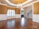 Bright living room with hardwood floors, large windows, and elegant chandelier, perfect for gatherings at 3850 Hounslow Ln, Harrisburg, NC 28075