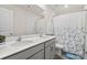 Bathroom featuring a double sink vanity with grey cabinets, a large mirror, and a shower/tub with a decorative curtain at 9142 Mackinaw Dr, Gastonia, NC 28056