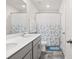 Bathroom showcases a double sink vanity with grey cabinets, a large mirror, and a shower/tub with a shower curtain at 9142 Mackinaw Dr, Gastonia, NC 28056