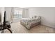 Cozy bedroom with a floral comforter on the bed, soft carpet, and natural light from the window at 9142 Mackinaw Dr, Gastonia, NC 28056