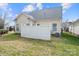 This backyard with sparse green grass features a white privacy fence and the home's vinyl siding at 1005 Jody Dr, Matthews, NC 28104