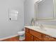 Well-lit bathroom with a wood vanity, decorative mirror, and hardwood floors at 1005 Jody Dr, Matthews, NC 28104