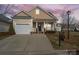 Charming front exterior of home with a two-car garage, driveway, and a cozy front porch at 1005 Jody Dr, Matthews, NC 28104