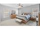 Bright main bedroom featuring a ceiling fan, carpet, two windows and a well-placed bed with stylish decorations at 1005 Jody Dr, Matthews, NC 28104