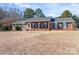 Charming brick home featuring green shutters, complemented by an expansive front yard at 101 Griffin St, Stanley, NC 28164