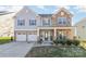 Two-story house with gray siding, stone accents, and a three-car garage at 10422 Ebbets Rd, Charlotte, NC 28273