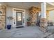 Front porch with stone columns, a gray door, and potted plants at 10422 Ebbets Rd, Charlotte, NC 28273