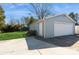 Detached one-car garage with white door and light blue siding, accessible via a concrete driveway at 11828 Mirror Lake Dr, Charlotte, NC 28226