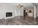 An open-concept living area with fireplace, wood floors and kitchen access at 11828 Mirror Lake Dr, Charlotte, NC 28226