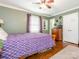 This bedroom features a ceiling fan, neutral walls, hardwood floors, and natural light at 1204 Allenbrook Dr, Charlotte, NC 28208