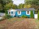 Charming blue house with a landscaped yard and white fence at 1204 Allenbrook Dr, Charlotte, NC 28208