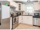 Bright kitchen featuring stainless steel appliances, white cabinets and a tile floor at 1204 Allenbrook Dr, Charlotte, NC 28208