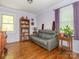 Cozy living room with hardwood floors, a gray sofa, bookshelf, and natural light from a window at 1204 Allenbrook Dr, Charlotte, NC 28208