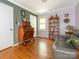 Bright living room with hardwood floors, a gray sofa, a bookshelf, and a wooden dresser at 1204 Allenbrook Dr, Charlotte, NC 28208