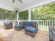 Covered outdoor patio with cozy blue seating, an area rug, and a patio heater for comfort at 1204 Allenbrook Dr, Charlotte, NC 28208