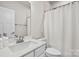 Well-lit bathroom with a white vanity, large mirror, toilet, and shower with a white curtain at 122 Lanyard Dr # C, Mooresville, NC 28117