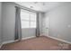 Bright bedroom with carpet flooring, window with blinds and grey curtains at 138 Augusta Ln, Shelby, NC 28150