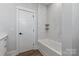 Clean bathroom with a tub and shower featuring tiled walls and a sleek glass shelf at 1846 Yardley St, Rock Hill, SC 29732