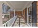 Spacious covered front porch with brick facade, windows with shutters, and white porch railing at 2205 E Brief Rd, Monroe, NC 28110