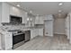 Modern kitchen featuring white cabinets, stainless steel appliances, and tiled backsplash at 2205 E Brief Rd, Monroe, NC 28110