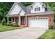 Brick and shingle front elevation of charming home with landscaping and two-car garage at 2324 Ryan Conley Ct, Gastonia, NC 28056