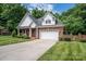 Brick and shingle front elevation of charming home with landscaping and two-car garage at 2324 Ryan Conley Ct, Gastonia, NC 28056