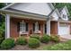 Brick front porch with white benches, landscaping, and black shutters at 2324 Ryan Conley Ct, Gastonia, NC 28056