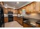 L-shaped kitchen with dark wood cabinets, granite countertops, and stainless steel appliances at 2324 Ryan Conley Ct, Gastonia, NC 28056