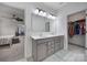 Bright bathroom featuring double sinks, a large mirror with vanity lighting, and access to a walk-in closet at 3155 Pinehills Way, Mount Holly, NC 28120