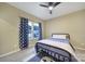 Cozy bedroom featuring a ceiling fan, window with curtains, and a comfortable bed with stylish nautical accents at 3155 Pinehills Way, Mount Holly, NC 28120