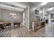 Open dining room featuring stylish wooden floors, rustic wooden table, and modern lighting fixtures at 3155 Pinehills Way, Mount Holly, NC 28120