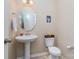 Clean and updated powder room with pedestal sink, toilet, and tiled flooring at 3322 Yarmouth Ln, Gastonia, NC 28056