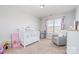 Bright Bedroom features a crib, chair, and window with curtains at 3322 Yarmouth Ln, Gastonia, NC 28056