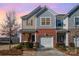 Two-story townhome with gray and beige siding, white garage door, and landscaping at 3322 Yarmouth Ln, Gastonia, NC 28056