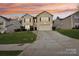 Two-story house with beige siding, two-car garage, and landscaped yard at sunset at 3366 Table Rock Dr, Gastonia, NC 28052